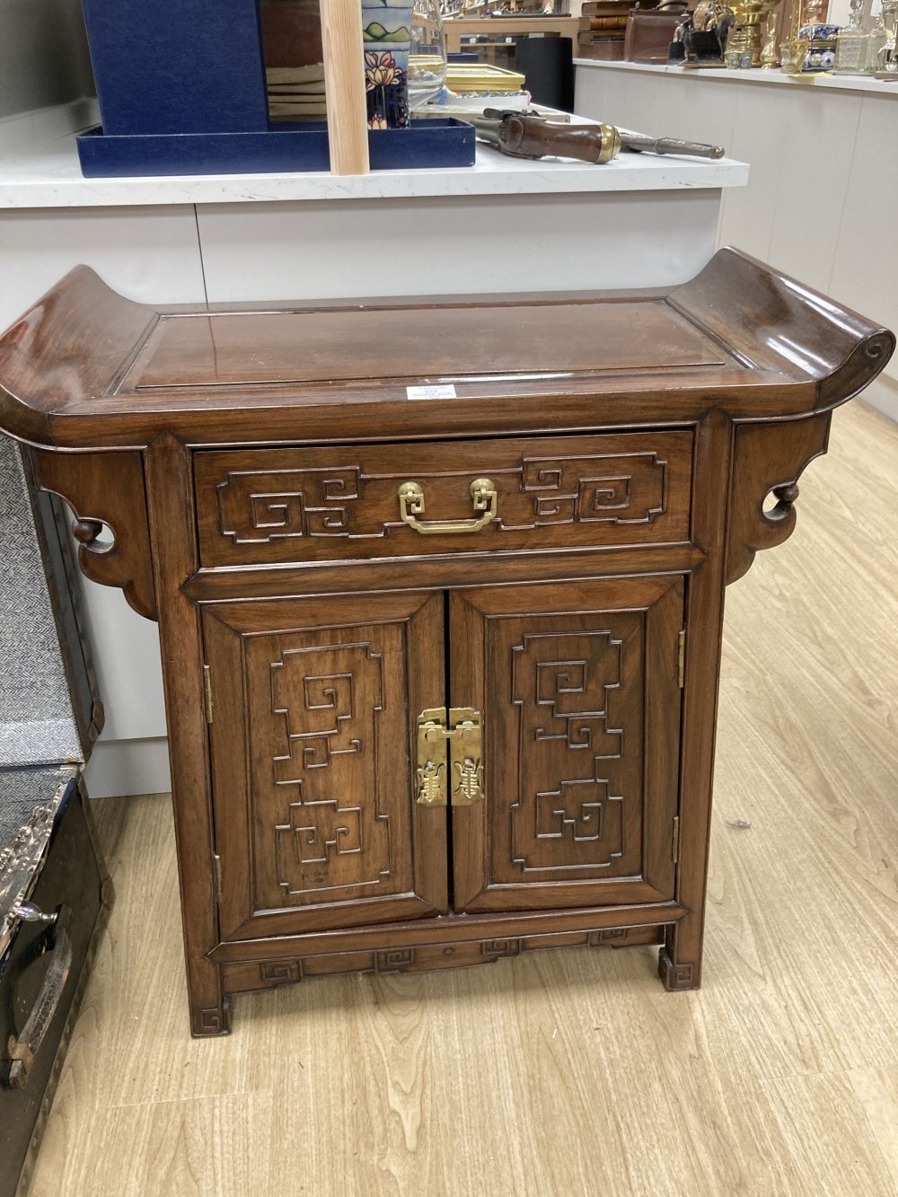 A Chinese carved hardwood side cabinet, fitted one long drawer over a pair of doors, width 70cm depth 38cm height 80cm